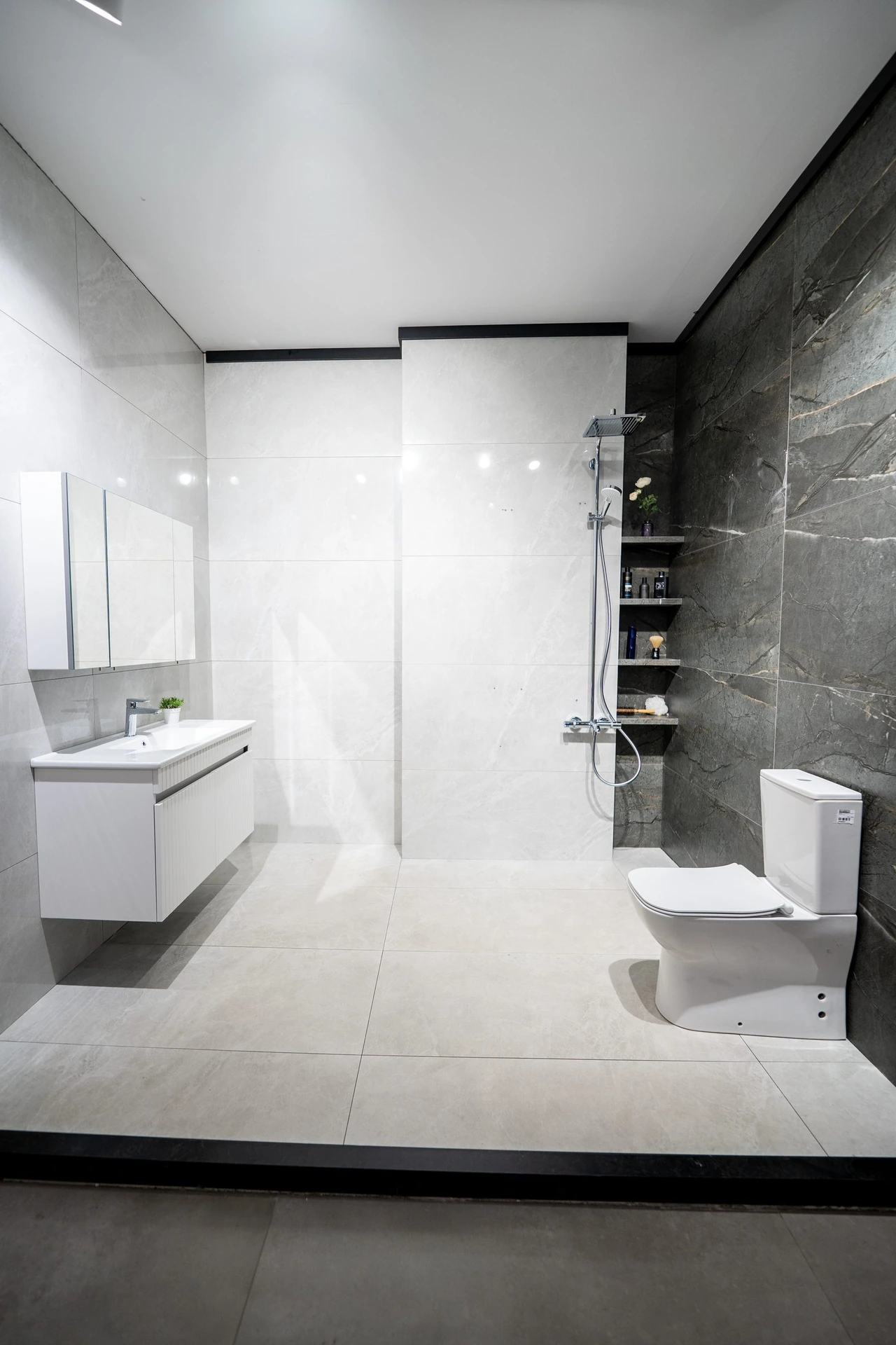 Gri büyük ebat seramikle kaplı komple banyo: duşakabin, klozet ve lavabo dolabı